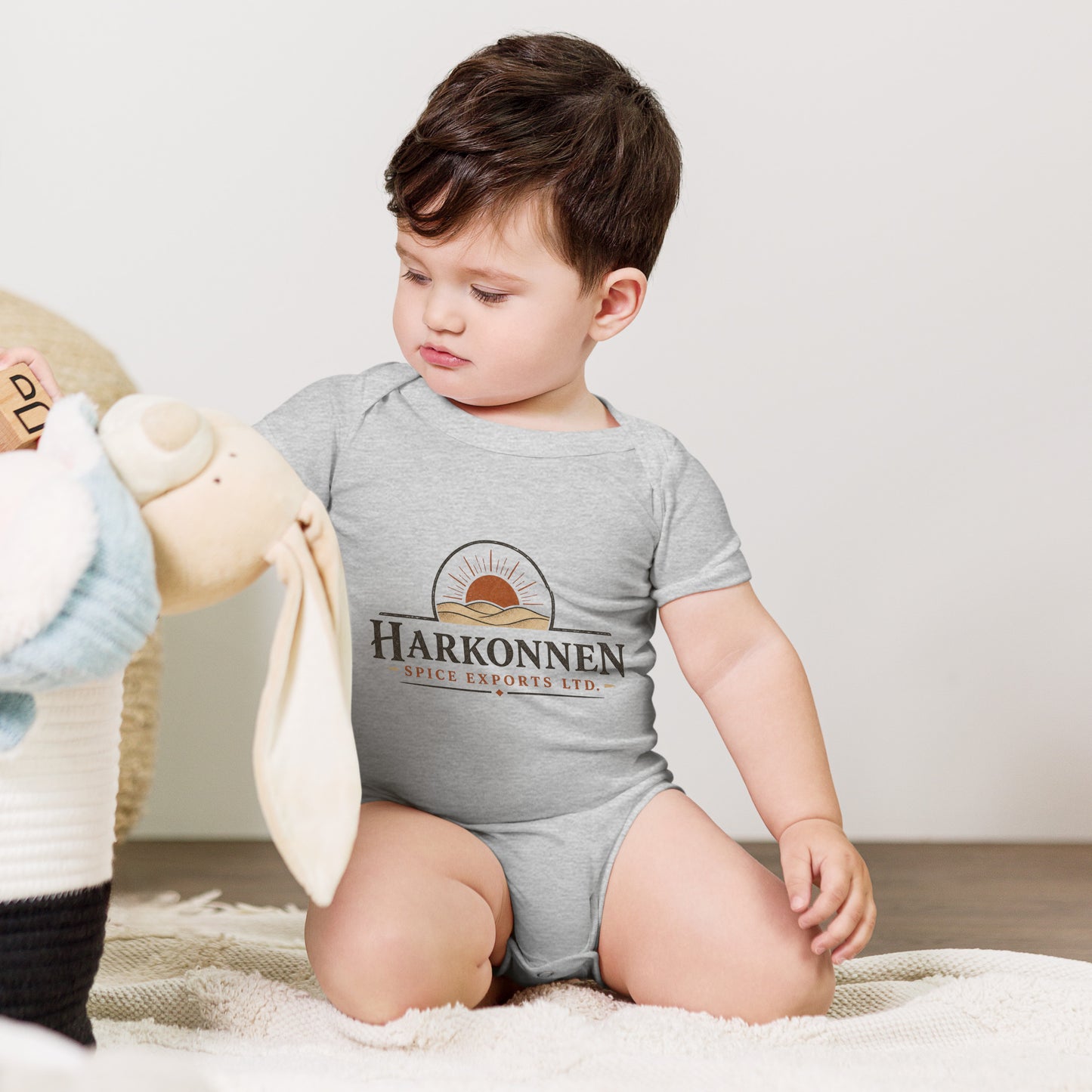 Baby bodysuit with a fictional trading company logo for Harkonnen Spice Exports Ltd