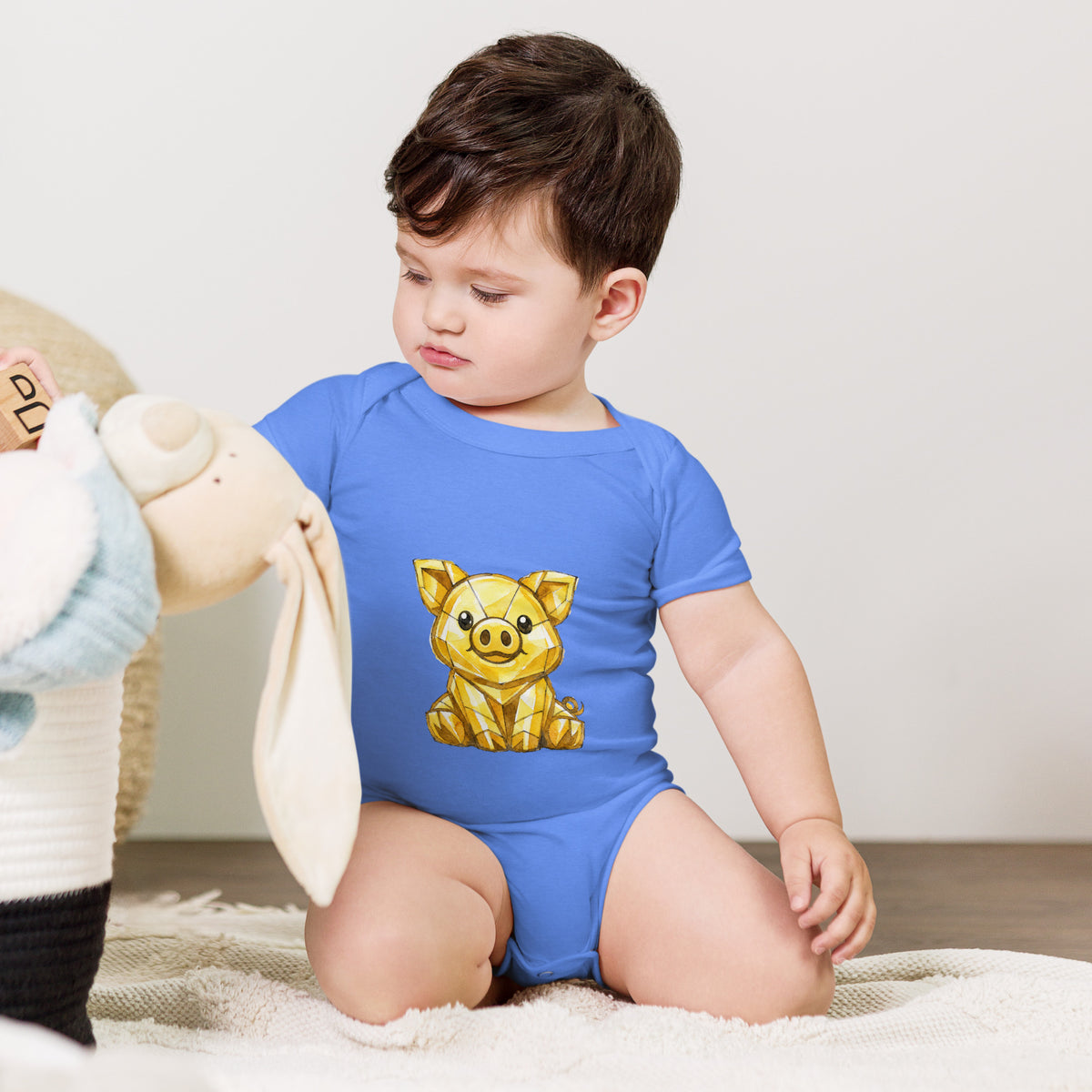 Baby bodysuit with a golden piggy print, worn by a baby