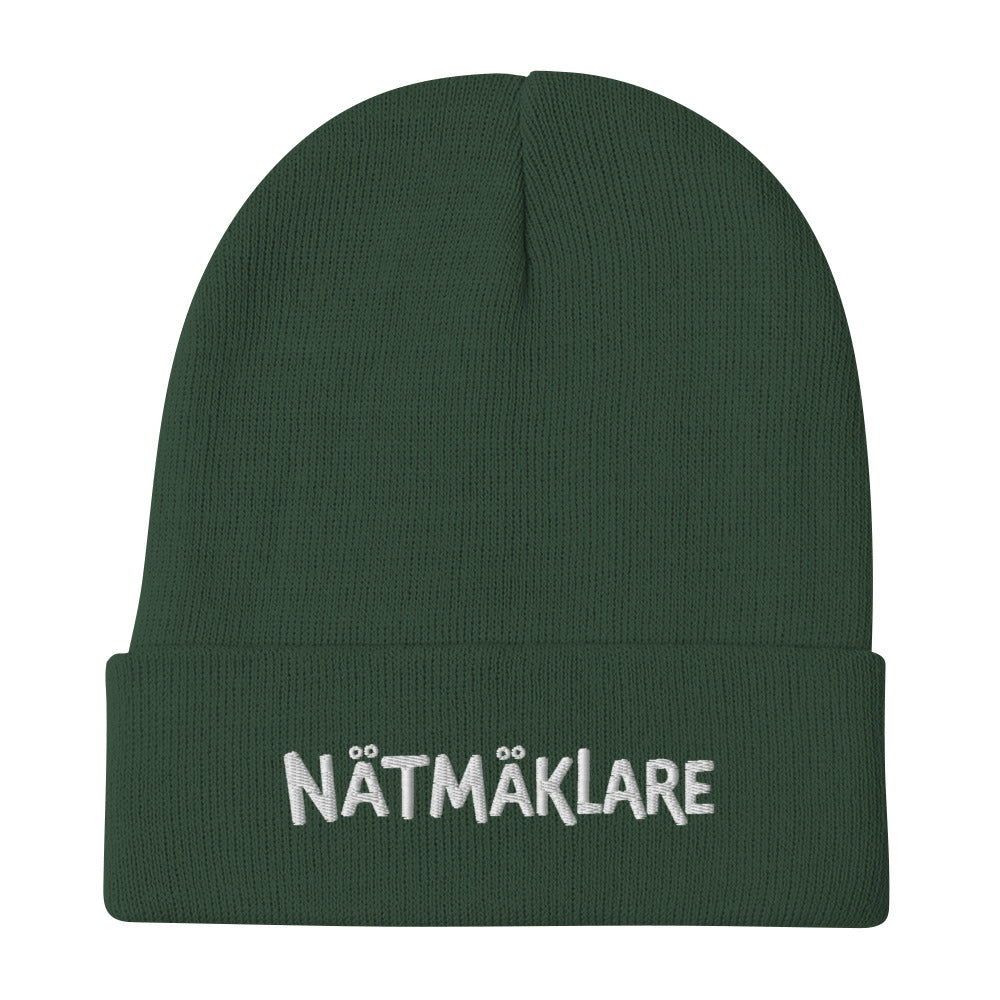 Stickad mössa med broderad Nätmäklare-text i versaler