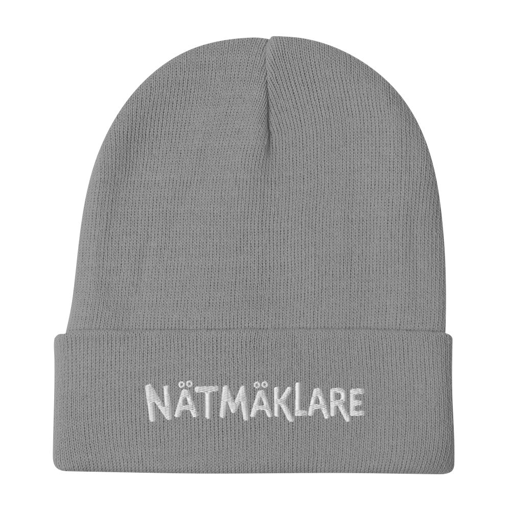 Stickad mössa med broderad Nätmäklare-text i versaler