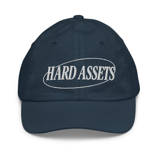 Youth baseball cap with the words Hard Assets in a serif typeface inside an oval badge outline